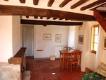 Il soggiorno con camino dell'appartamento Pianza nel casale Certino a Grotti in Toscana, 12 km da Siena