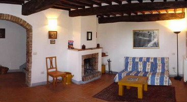 Livingroom with fireplace of the apartment Siena in the 
        farmhouse Certino in Grotti - Siena