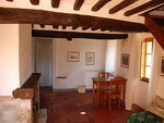 Il soggiorno con camino dell'appartamento Pianza nel casale Certino a Grotti in Toscana, 12 km da Siena