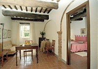 Il soggiorno dell'appartamento Mucca-I nel parco dell'Agriturismo Castello di Grotti a 12 km da Siena, in Toscana
